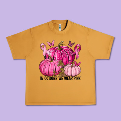 In October We Wear Pink With Pumpkin Urban Heavy Tee Designed By Texasbilliewilder