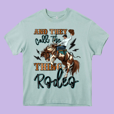 And They Call The Thing Rodeo Cowboy Heavy Core Tee Designed By Maliassmallbusiness