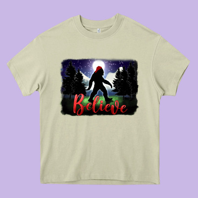 Bigfoot Believe Christmas Heavy Core Tee Designed By Fadigitalartstudio